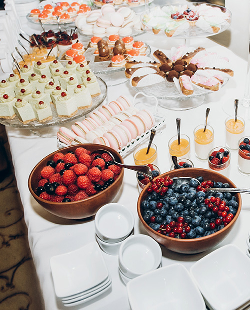 Different types of pastries, cakes and fruits on the table